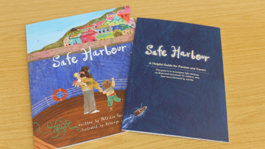 A photo of "Safe Harbour", a storybook for children bereaved by suicide, and its accompanying guide for parents and carers.